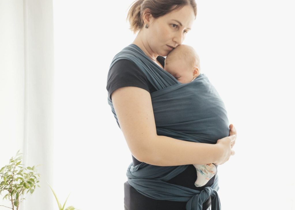 Get things done with a baby by babywearing: mom wearing baby in a green wrap