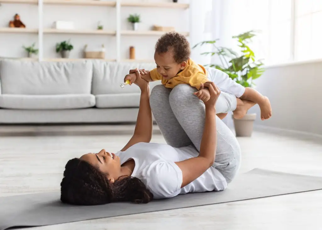 movement: mom exercising with her baby on a yoga mat in her house