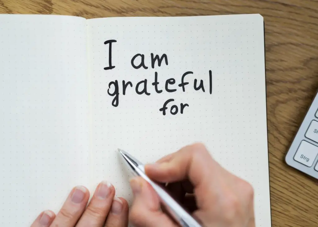 gratitude: mom writing i am grateful for in a journal