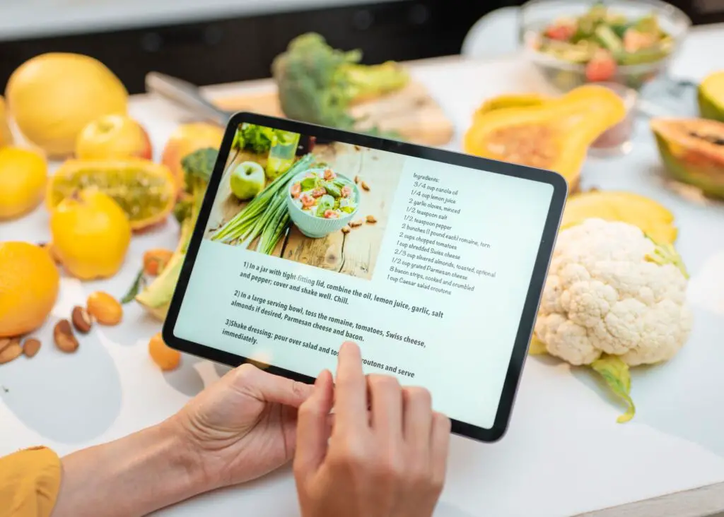 meal planning digitally: recipe on tablet with ingredients blurred in the background
