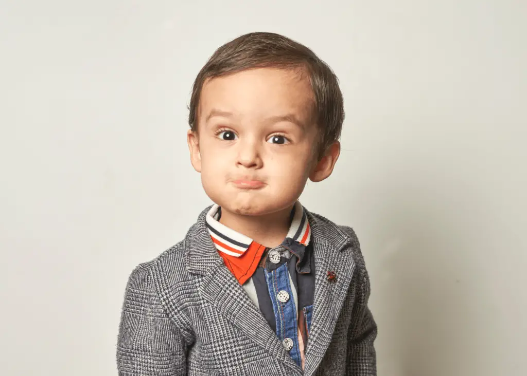 Dapper toddler boy in suit jacket and button up shirt: unique middle names for jack