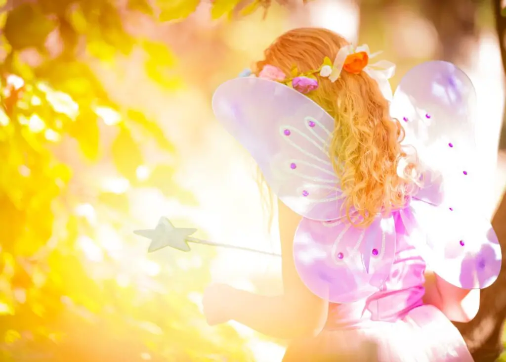 magical names for girls: fairy girl facing sun shining through trees