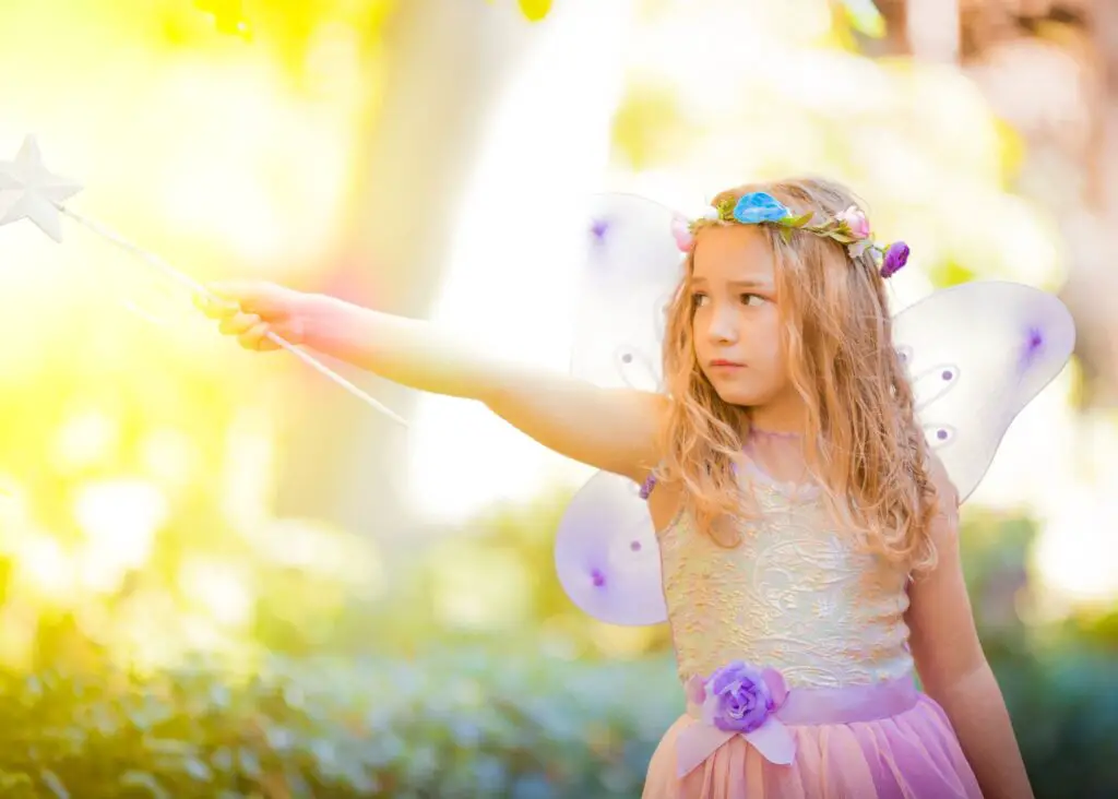 mystical names: fairy child with flower crow pointing wand left in nature setting